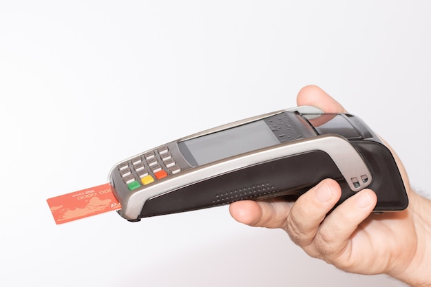 Person holding a payment terminal with a red credit card swiped through the machine