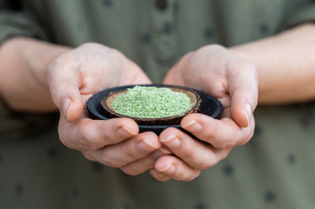 Free photo person holding a plate of green powder used for raw vegan foods