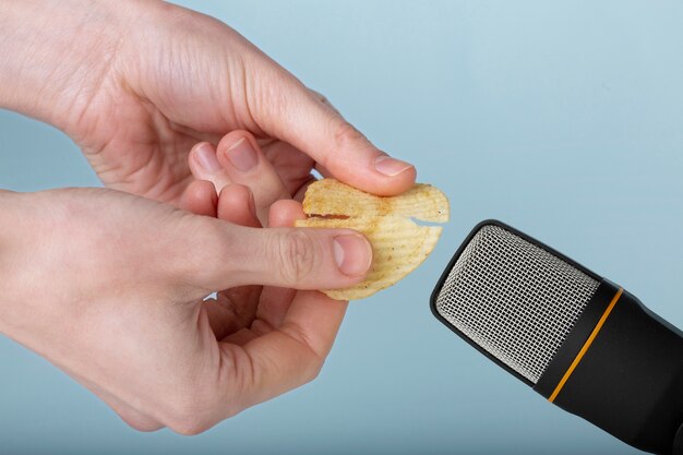 Person holding potato chips close to microphone for asmr