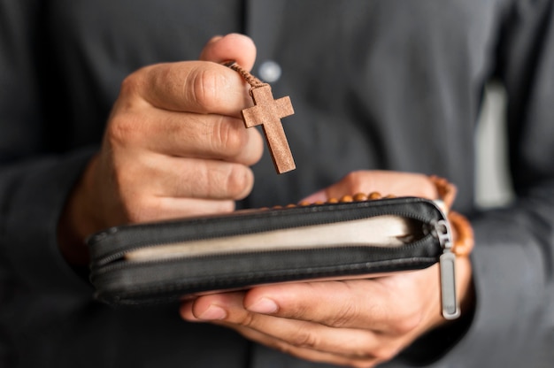 Person holding rosary and holy book