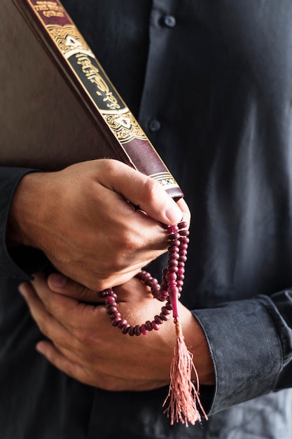 Free photo person holding rosary and religious book