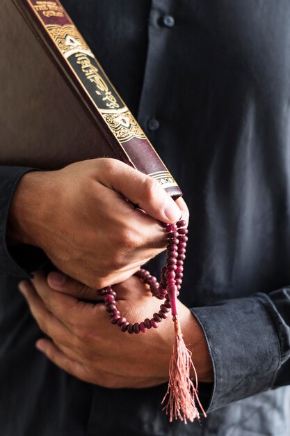 Person holding rosary and religious book