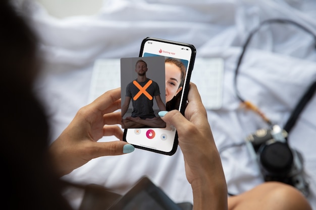 Бесплатное фото Человек, держащий смартфон с приложением для знакомств