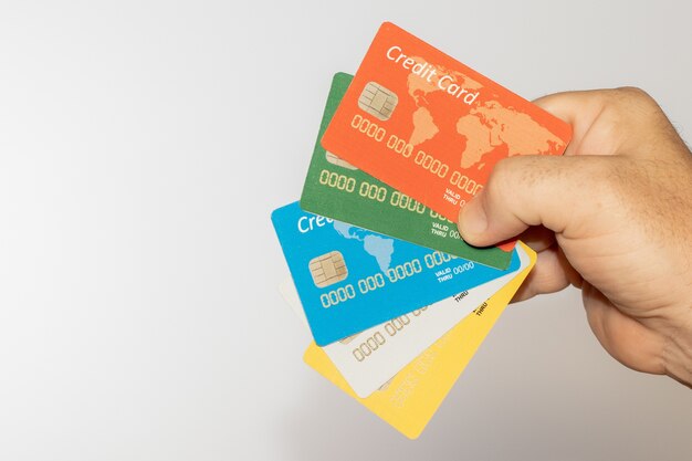 Person holding some colorful credit cards over a white