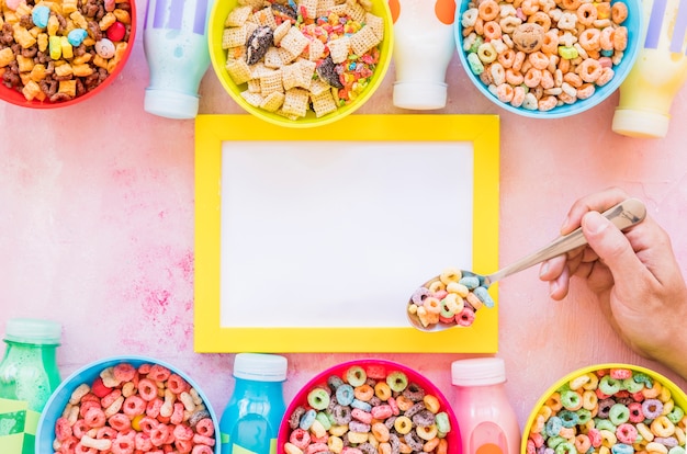 Free photo person holding spoon with cereal above frame