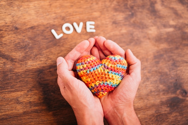 Free photo person holding toy heart in hands