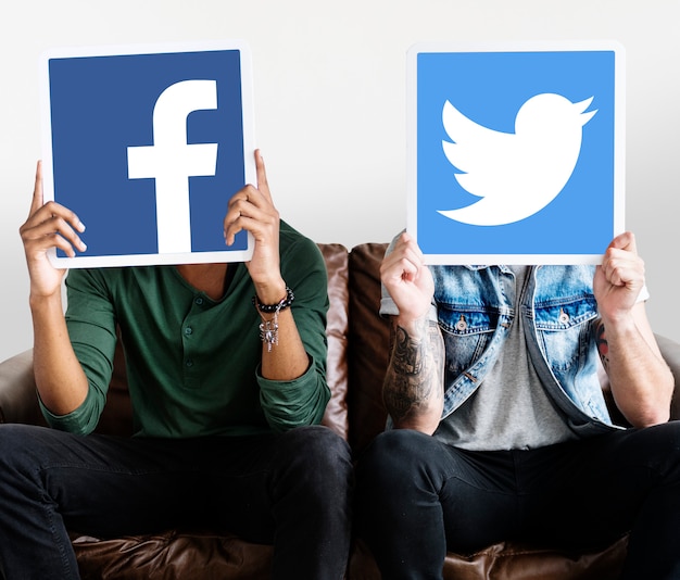 Person holding two social media icons
