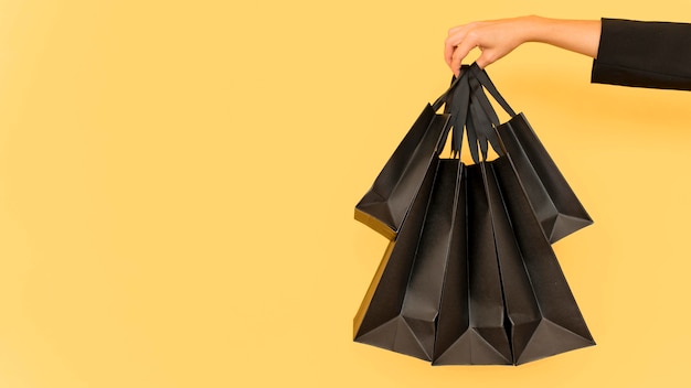 Бесплатное фото Лицо, занимающее различные размеры черных хозяйственных сумок
