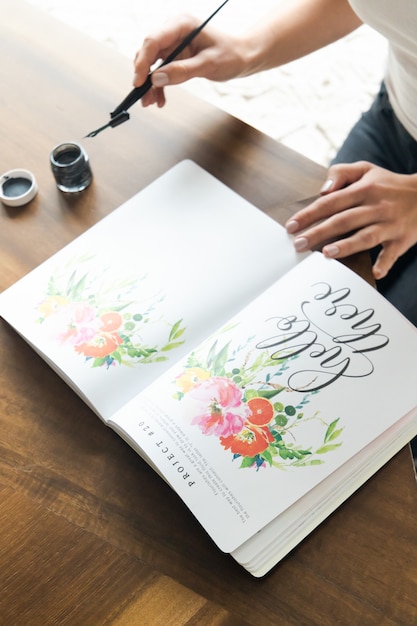 Free photo person holding white and pink floral book