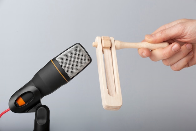 Person holding wooden toy close to microphone for asmr