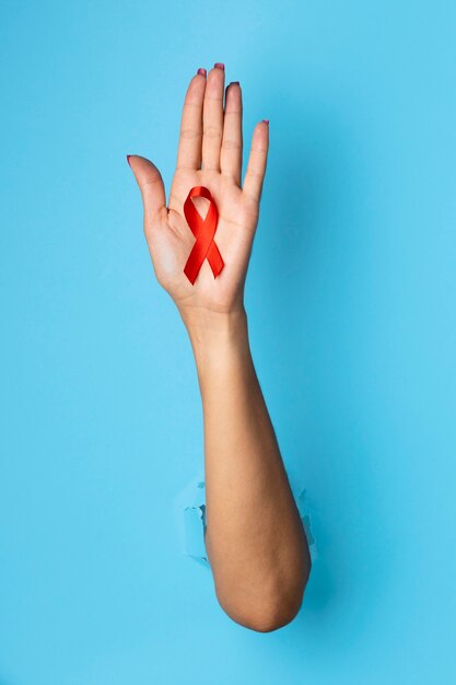 Person holding an world aids day red symbol