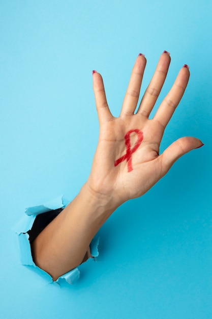 Free photo person holding an world aids day red symbol