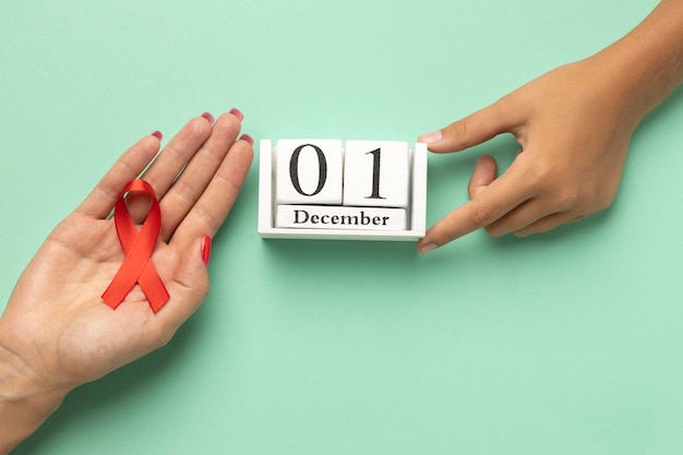 Free photo person holding an world aids day ribbon symbol with the event date