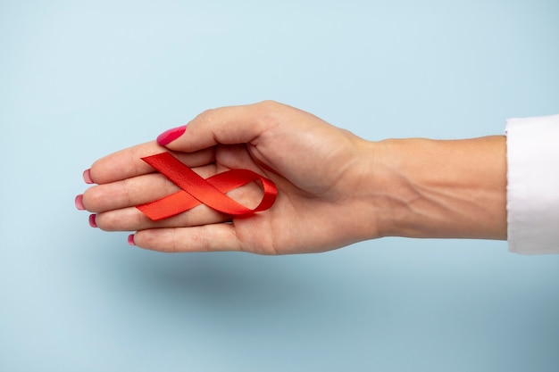 Person holding an world aids day ribbon symbol