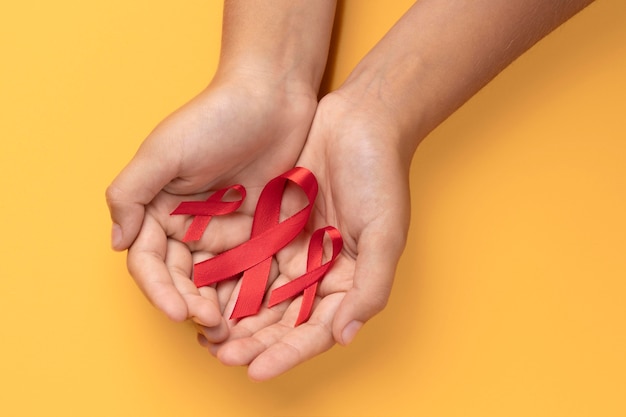 Лицо, держащее символ ленты Всемирного дня борьбы со СПИДом