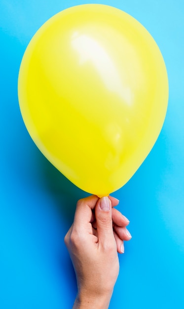 Person holding yellow balloon