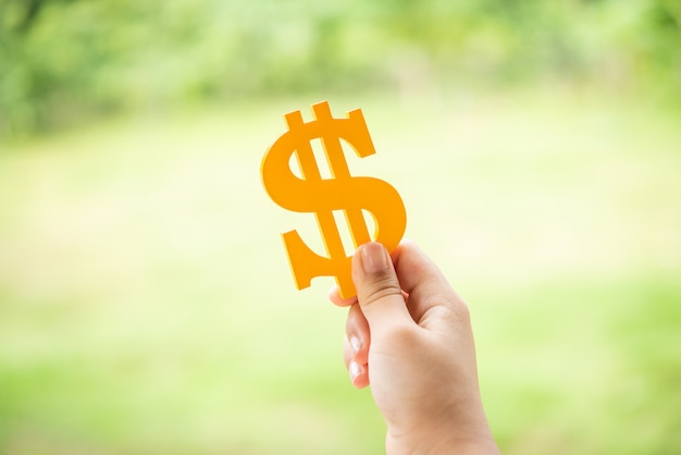 Person holding yellow dollar sign