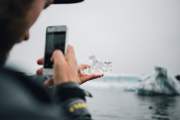 人はアイスランドで氷河の氷のかけらを持っています