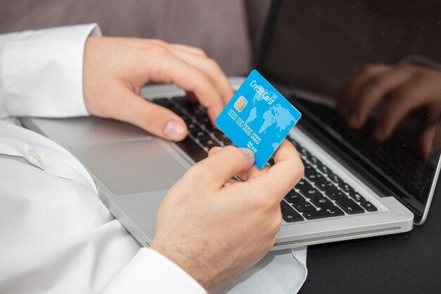 Person inputting details of its credit card in the laptop