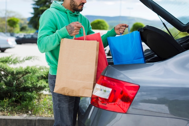 Free photo person keeping shopping bags inside the car