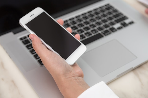  person looking at a laptop and a mobile