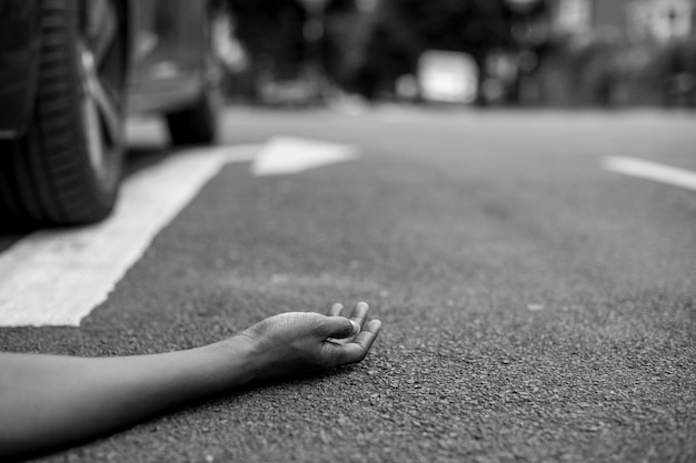 Free photo person lying on the ground after a car accident