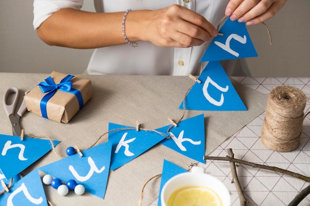 Person making a happy hanukkah garland