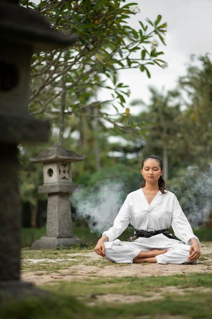 Foto gratuita persona che medita prima dell'allenamento di taekwondo