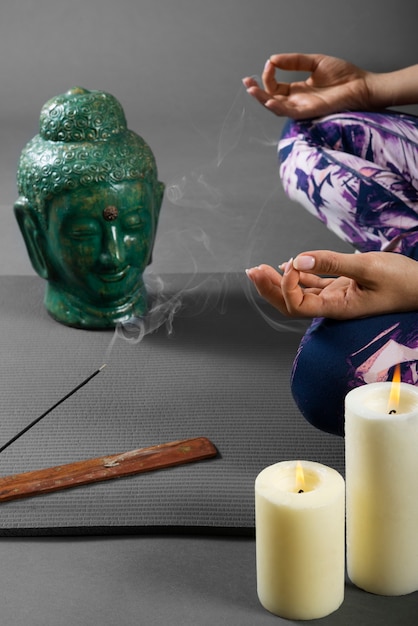 Free photo person meditating next to buddha statuette