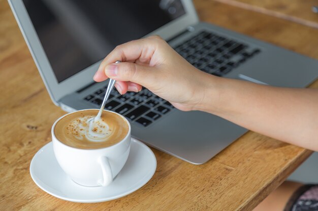 ティースプーンでコーヒーを移動する人