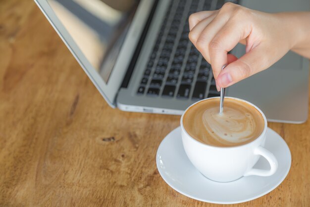 ティースプーンでコーヒーを移動する人