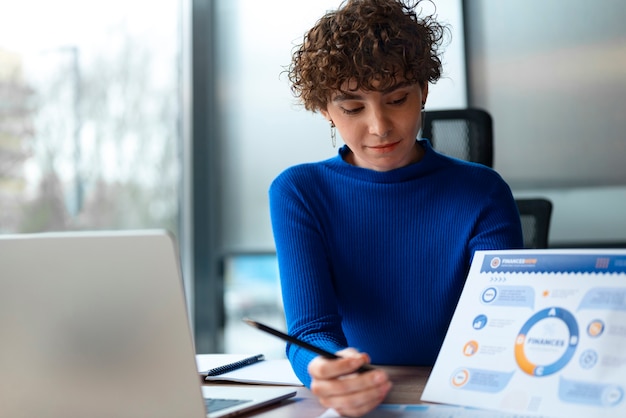 Free photo person in the office analyzing and checking finance graphs