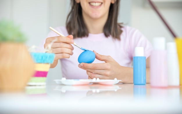 Person painting egg at table