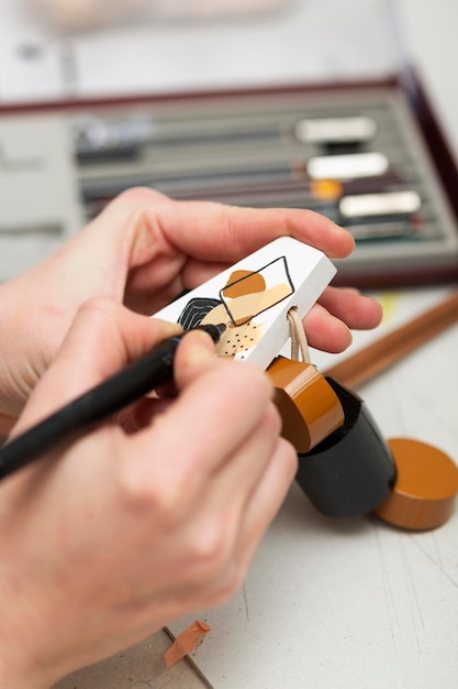 Person painting a piece of wood