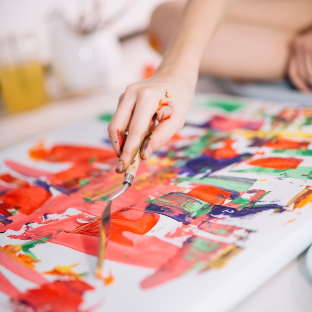 Person painting with gouache on canvas