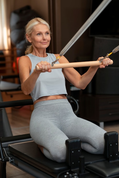 Free photo person in pilates reformer class exercising their body