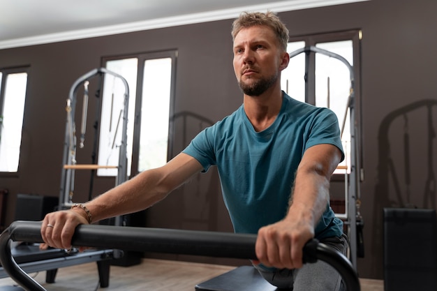 Free photo person in pilates reformer class exercising their body