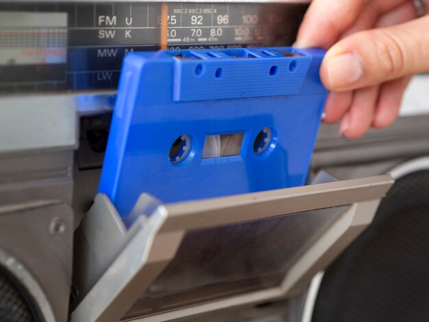 음악 플레이어에 파란색 카세트 테이프를 배치하는 사람