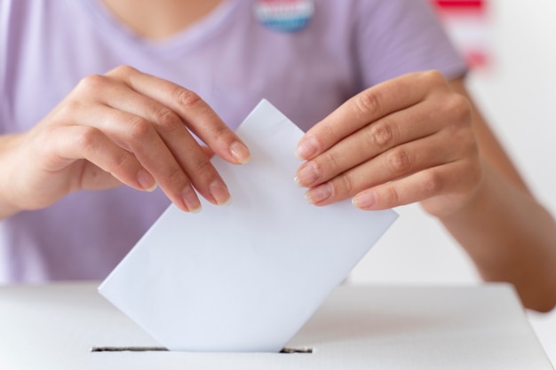 Foto gratuita persona che mette il suo voto in una casella