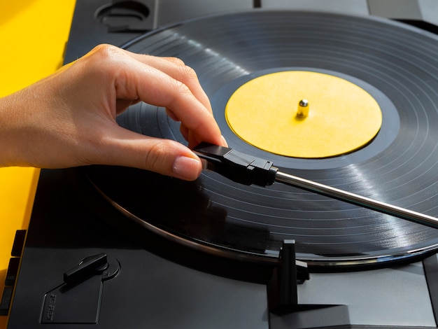 Foto gratuita persona che inserisce il disco in vinile nel lettore