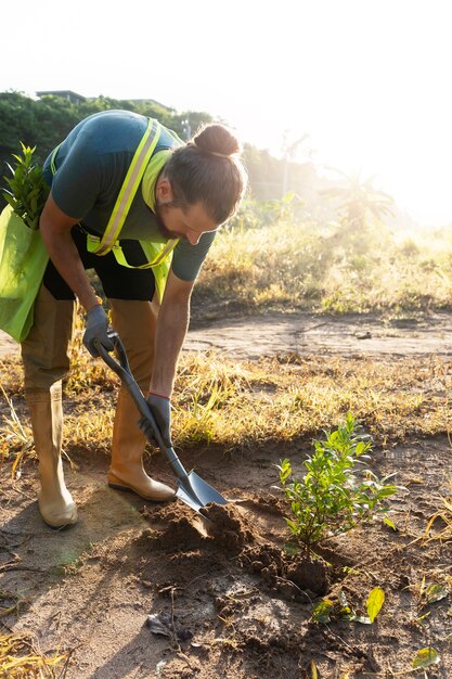 Person planting tree on the countryside