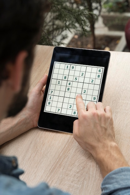 Foto gratuita persona che gioca a un gioco di sudoku su un tablet