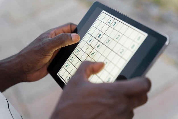 Person playing sudoku on a tablet