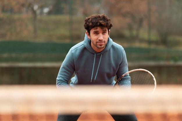Free photo person playing tennis game in winter time