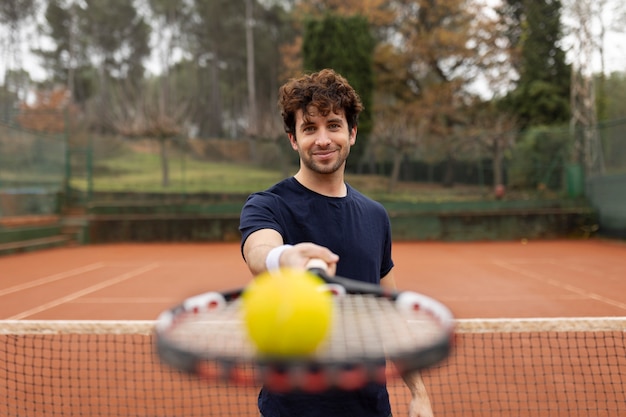 Free photo person playing tennis game in winter time