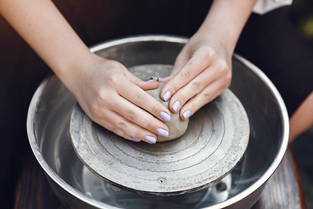 Free photo person playing with clay on the pottery machine