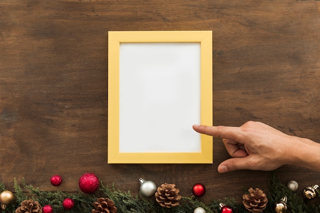 Person pointing on frame on brown table