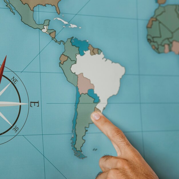 Person pointing to south america on the map