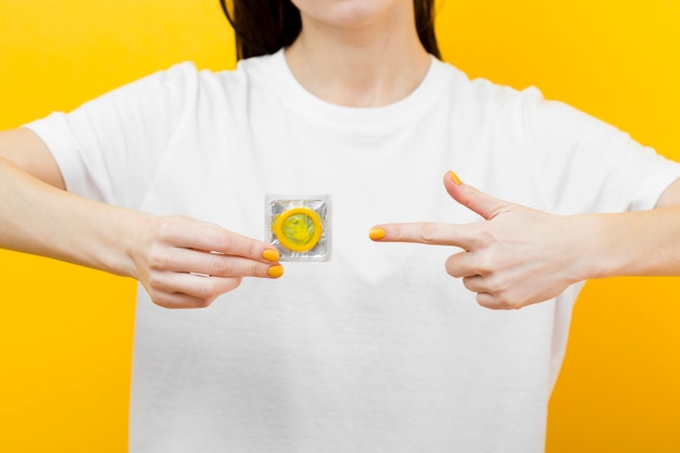 Лицо, указывающее на желтый презерватив