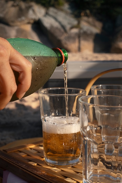 Foto gratuita persona che versa la bevanda di guaranà in vetro dalla bottiglia